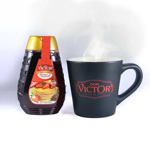 Bottle of Don Victor natural strawberry flavored honey beside a steaming mug of hot honey tea.