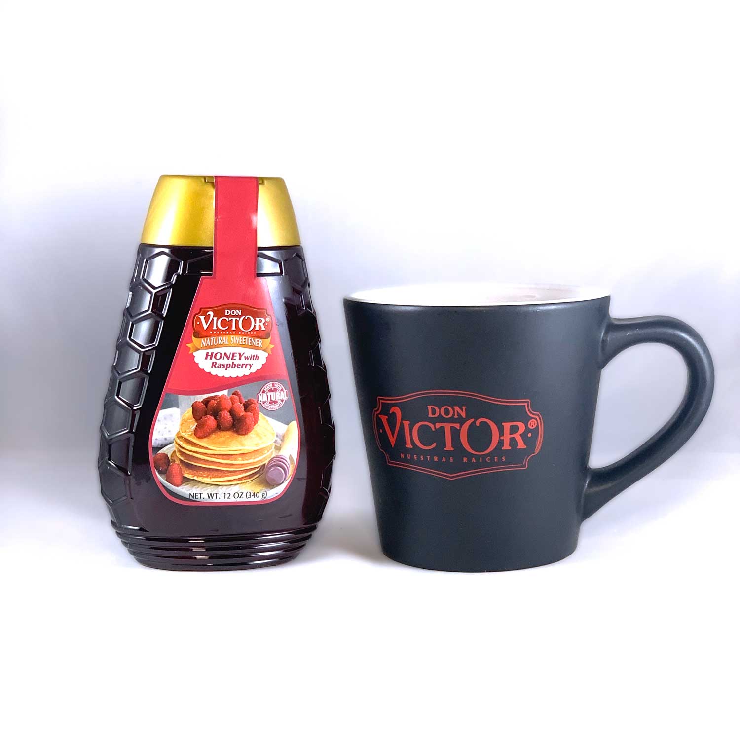 Bottle of Don Victor natural raspberry flavored honey beside a steaming mug of hot black tea.